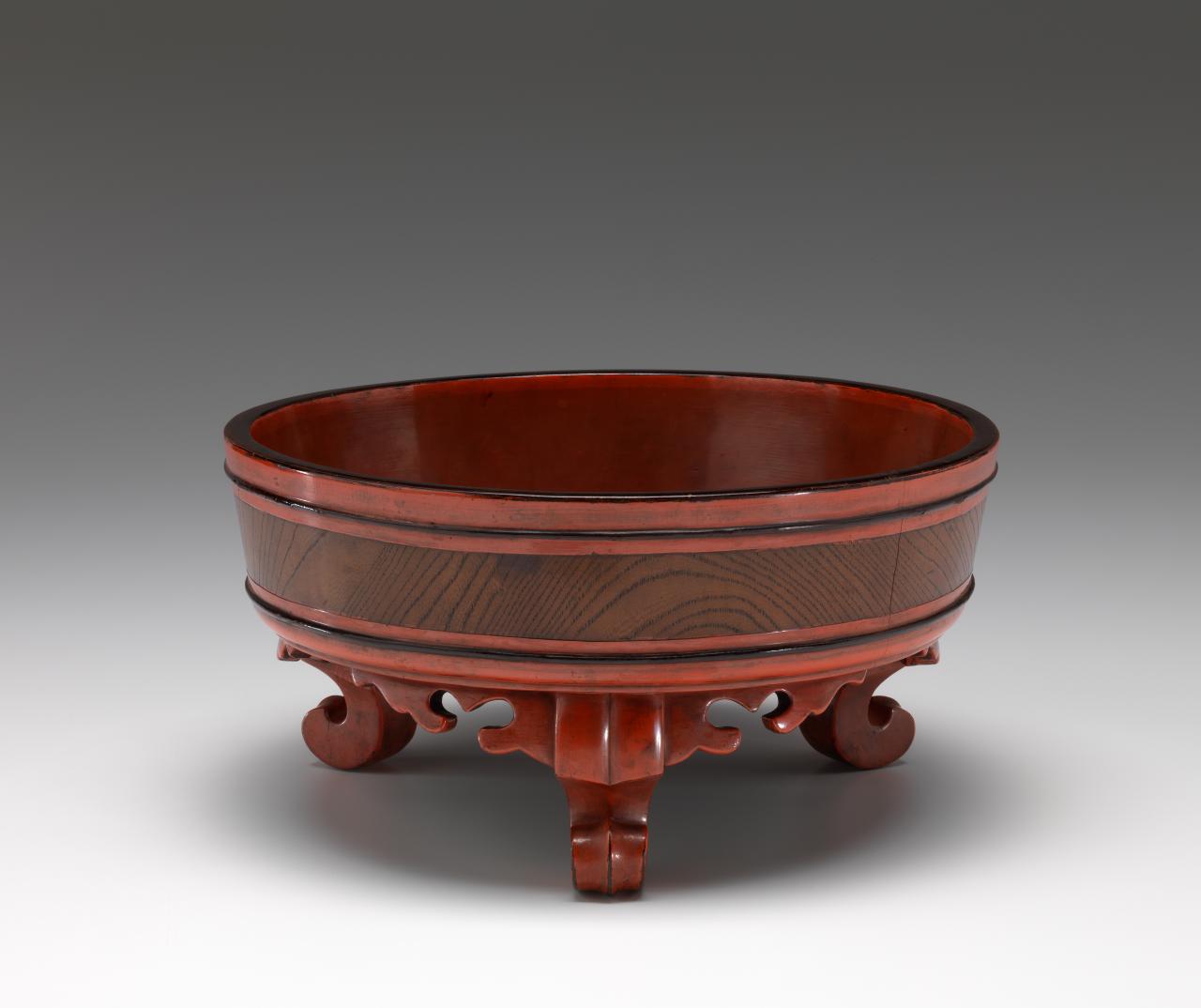 JAPANESE <br/>
<em>Basin with legs</em><br />
<em>Ashitsuki tarai</em><br />
Muromachi period 14th century, Japan<br />
lacquer on wood (Negoro lacquer) <br />
Presented through The Art Foundation of Victoria by Mr S. Baillieu Myer, Founder Benefactor, 1985 (AS34-1985)<br />