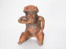Seated figure with exposed spinal column