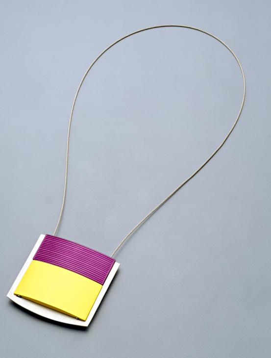 Johannes KUHNEN<br/>
<em>Pendant</em> (1999) <!-- (full view) --><br />

anodised aluminium, stainless steel<br />
5.6 x 5.5 x 0.8 cm (pendant) 25.0 x 14.0 x 0.8 cm (overall)<br />
National Gallery of Victoria, Melbourne<br />
Loffler Bequest, 1999<br />
1999.398<br />
© Courtesy of the artist
<!--66802--><br/><a class="col-link block" href="/explore/collection/work/66802"><strong>Collection page <i class="fa fa-angle-right"></i></strong></a>