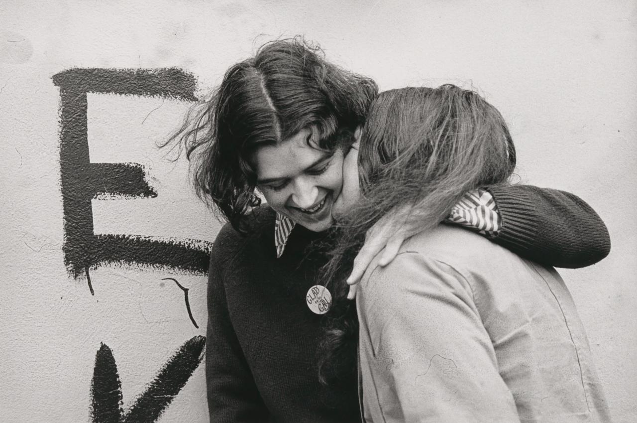 Ponch HAWKES<br/>
<em>No title (Two women embracing, 'Glad to be gay')</em> (1973); (2018) {printed} <!-- (recto) --><br />

gelatin silver photograph<br />
20.2 x 30.3 cm (image) 28.0 x 38.0 cm (sheet)<br />
National Gallery of Victoria, Melbourne<br />
Purchased NGV Foundation, 2018<br />
2018.1372<br />
© Ponch Hawkes, 2018
<!--137840-->