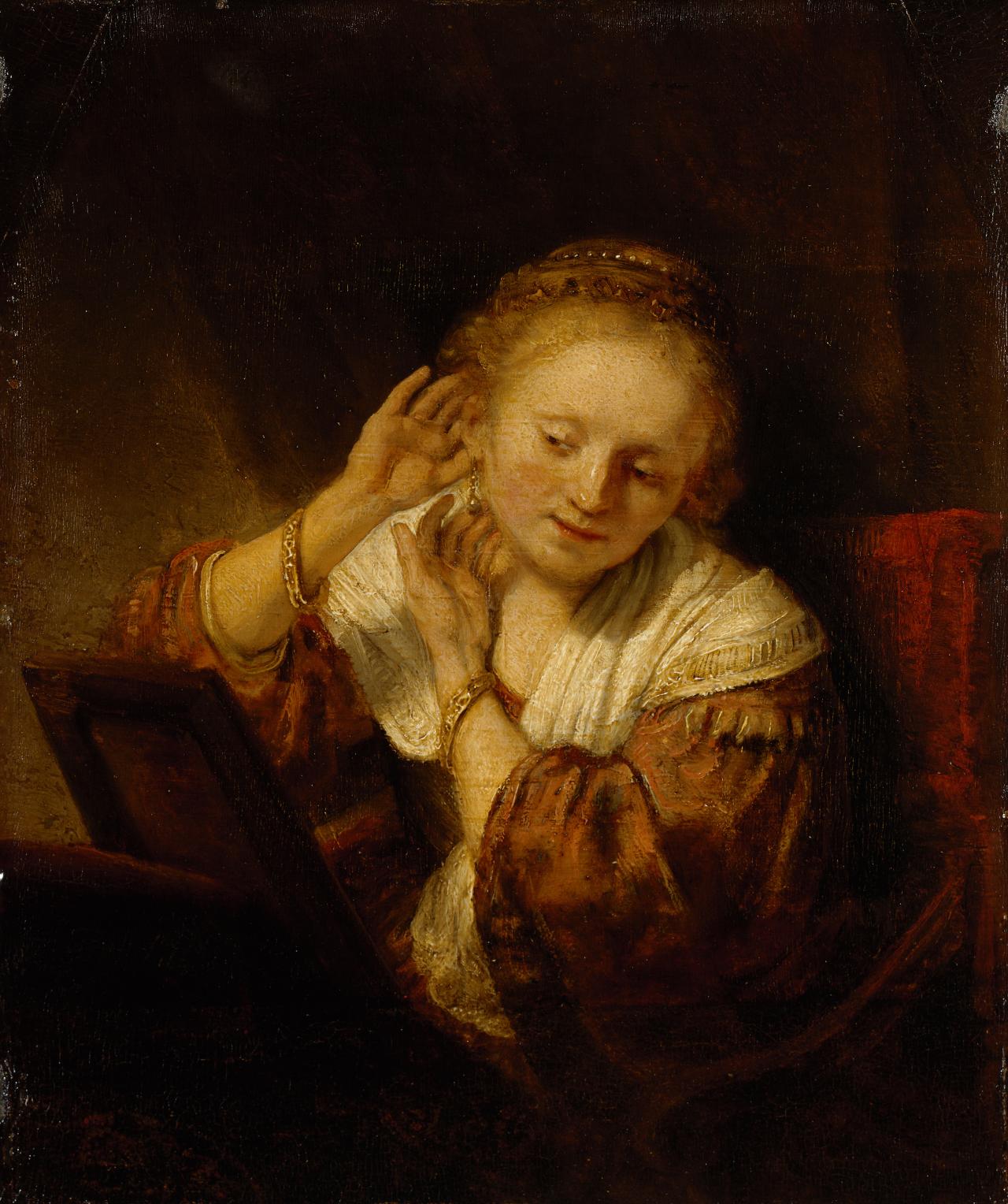 Rembrandt Harmensz. Van Rijn <br/>
Dutch 1606–1669<br/>
<em>Young woman trying on earrings</em> 1657 <br/>
oil on wood panel <br/>
39.5 х 32.5 cm <br/>
The State Hermitage Museum, St Petersburg <br/>
(Inv. no. ГЭ-784) <br/>
Acquired from the collection of the Comte <br/>
de Baudouin, Paris, 1781<br/>