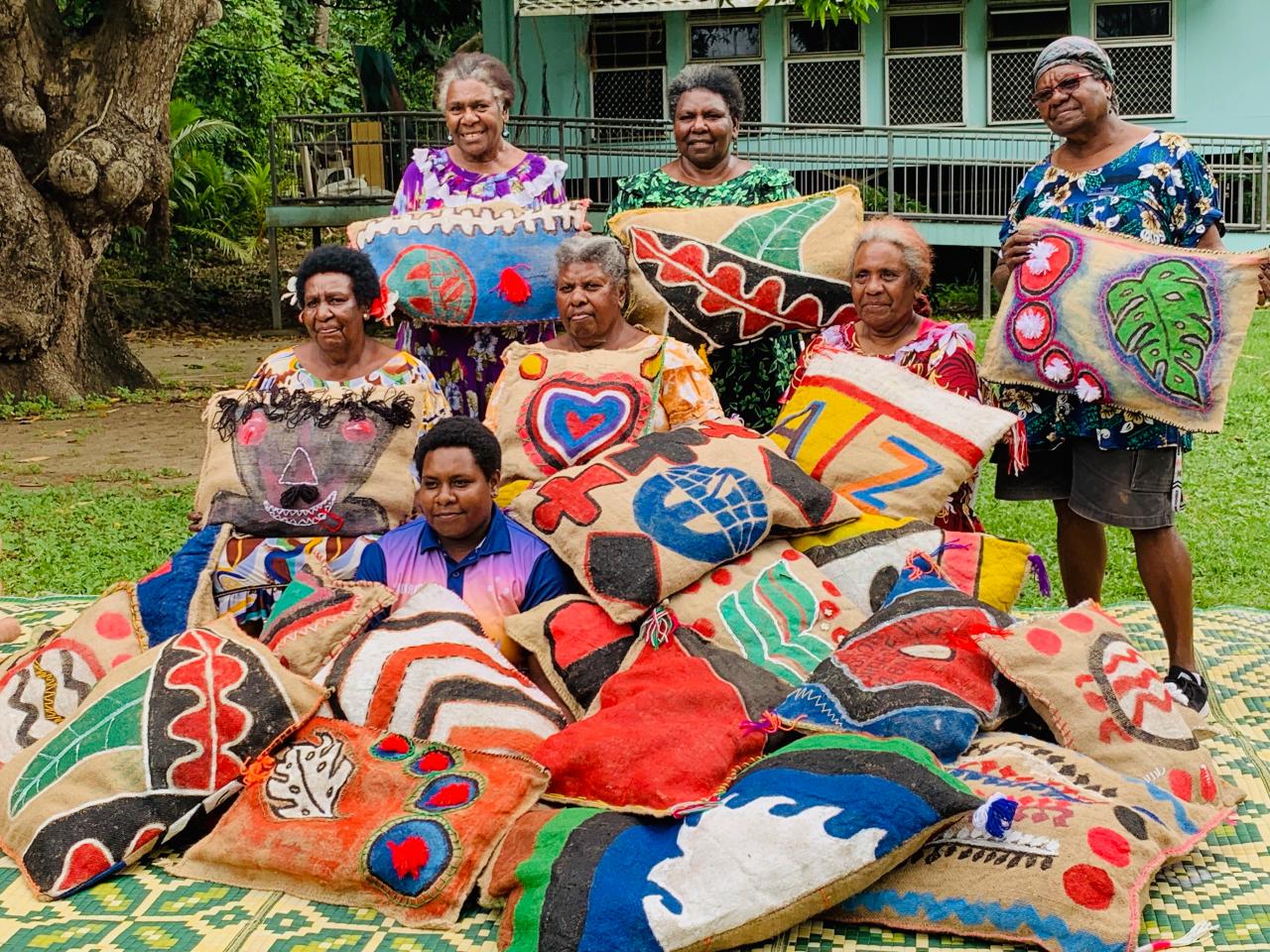 Marep Pamle artists (from top left) Kalina Day, Nellie Passi, Mary Kaigey, Helen Mabo, Helen Dick, Dulcie Anne Gibas, and Reteah Tapim <br/>
<em>Mas, cushions</em> 2019<br/>
jute, fabric paint, corn fibre, thread<br/>
Photography courtesy NGV<br/>
© The artists