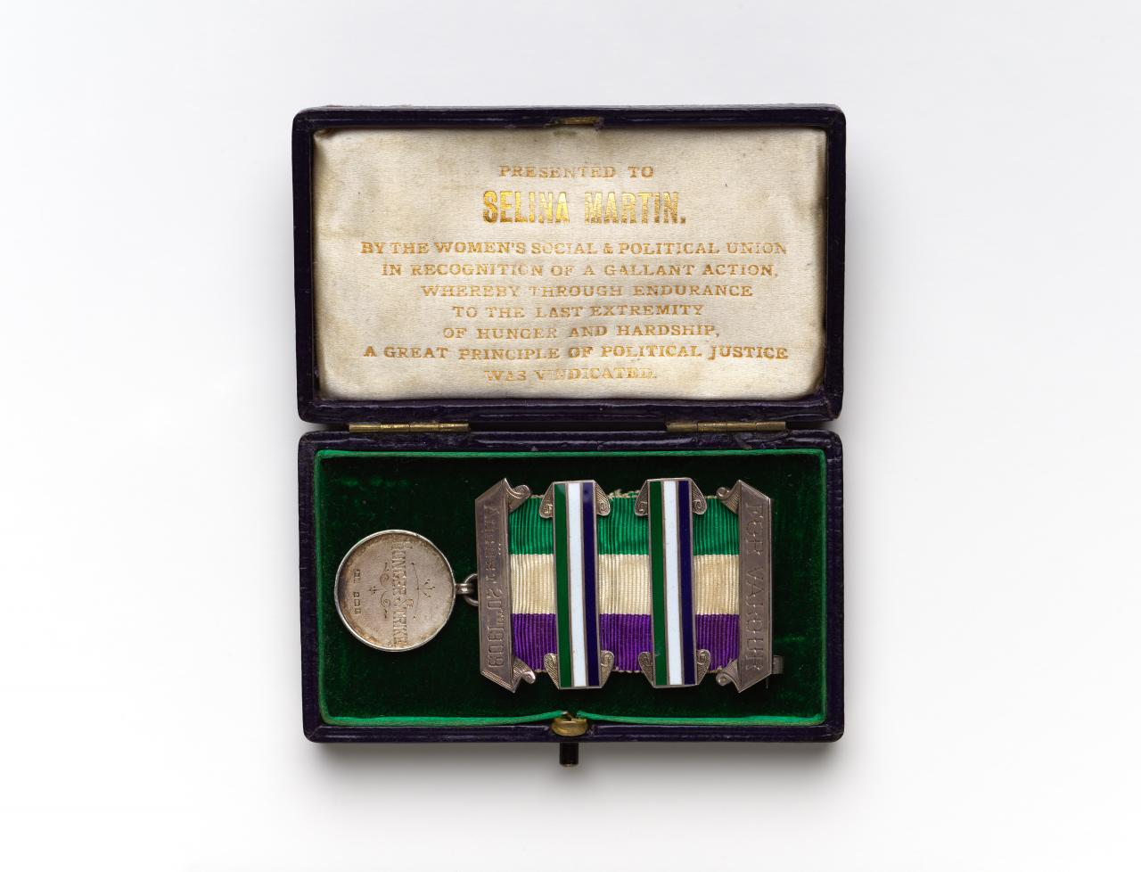 WOMEN’S SOCIAL AND POLITICAL UNION, London (distributor)<br />
 TOYE & CO., London (manufacturer)<br/>
<em>Medal for valour, awarded to Selina Martin, with original box</em> 1909 <!-- (front) --><br />

silver, silk, enamel, metal<br />
8.0 x 3.8 x 0.4 cm (medal) 9.6 x 5.5 x 1.9 cm (box) (closed)<br />
National Gallery of Victoria, Melbourne<br />
Gift of Krystyna Campbell-Pretty AM and Family through the Australian Government's Cultural Gifts Program, 2019<br />
2019.677<br />

<!--140912-->