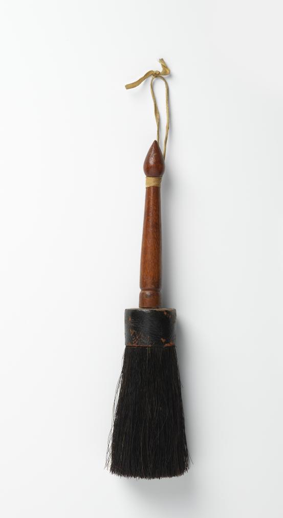 UNITED STATES, New England (manufacturer)<br/>
<em>Brush</em> (late 19th century) <!-- (view 1) --><br />

wood, horse hair, leather, ribbon (cotton)<br />
22.8 x 5.2 x 4.6 cm<br />
National Gallery of Victoria, Melbourne<br />
Marjorie Josephs-Wilks Bequest, 2025<br />
<br />

<!--157941-->