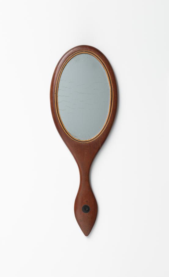 UNITED STATES, New England (manufacturer)<br/>
<em>Hand mirror</em> (late 19th century) <!-- (view 1) --><br />

wood, mirror<br />
19.2 x 7.0 x 0.4 cm<br />
National Gallery of Victoria, Melbourne<br />
Marjorie Josephs-Wilks Bequest, 2025<br />
<br />

<!--158417-->