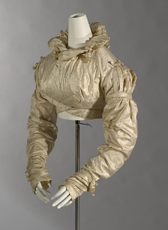 (ENGLAND)<br/>
<em>Spencer</em> (c. 1819) <!-- (front 3/4 left) --><br />

figured silk, plant material<br />
39.0 cm (centre back) 67.5 cm (sleeve length)<br />
National Gallery of Victoria, Melbourne<br />
Purchased, 1972<br />
D24-1972<br />

<!--45326-->