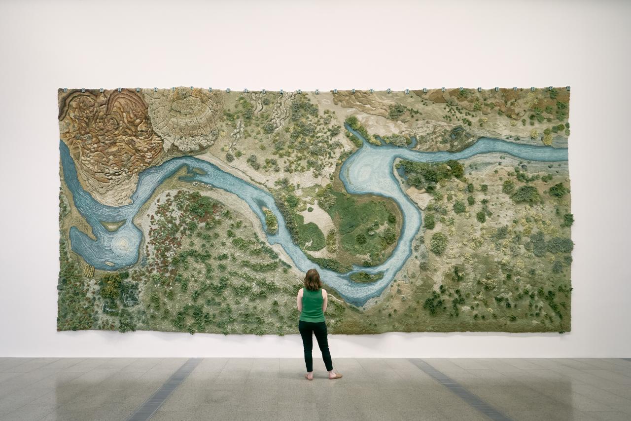 An installation view of the exhibition <em>We Change the World</em>  featuring Alexandra Kehayoglou’s monumental hand-tufted woollen rug, <em>Santa Cruz River</em>, 2017. Photo: Tom Ross<br/>
© Alexandra Kehayoglou